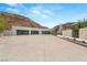 A modern home's sprawling driveway with several garage doors is nestled against a picturesque hillside at 3 Horseshoe Rock Ct, Henderson, NV 89012