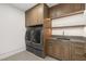 Well-organized laundry room with modern washer and dryer units, cabinets, and countertop space at 3 Horseshoe Rock Ct, Henderson, NV 89012