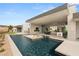 The backyard features a pool with water features, an outdoor kitchen, and a fire pit, perfect for luxury outdoor living at 3 Horseshoe Rock Ct, Henderson, NV 89012