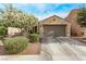 Charming single-story home featuring a two-car garage, desert landscaping, and flowering tree at 3005 Dotted Wren Ave, North Las Vegas, NV 89084