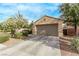 Attractive single-story home featuring a two-car garage, desert landscaping, and flowering tree at 3005 Dotted Wren Ave, North Las Vegas, NV 89084
