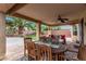 Covered patio with dining table, fan, and a comfortable outdoor seating area at 3005 Dotted Wren Ave, North Las Vegas, NV 89084