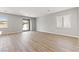 Spacious living room featuring wood-look floors, large windows, and a sliding glass door to the backyard at 3237 Walker River St, North Las Vegas, NV 89032