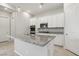 Kitchen with granite island, stainless steel appliances, tile floors, and white cabinets at 354 Spotted Dove St, Las Vegas, NV 89138