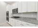 Kitchen with granite counters, sleek stainless steel appliances, gas cooktop, and white cabinets at 354 Spotted Dove St, Las Vegas, NV 89138