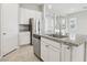 Kitchen island with stainless dishwasher, sink, white cabinets, granite counters, and tile floors at 354 Spotted Dove St, Las Vegas, NV 89138