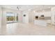 Bright, open-concept living space with a kitchen and living room featuring large tile floors and sliding glass doors to the patio at 354 Spotted Dove St, Las Vegas, NV 89138