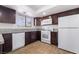 Bright kitchen featuring wood-look tile, granite countertops, white appliances, and dark brown cabinetry at 3937 S Torrey Pines Dr, Las Vegas, NV 89103