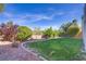 Well-maintained backyard featuring lush green grass, mature landscaping, and a peaceful setting at 4012 Owlshead Mountain St, Las Vegas, NV 89129