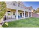 Spacious backyard featuring a covered patio, lush lawn, and access from multiple points at 4012 Owlshead Mountain St, Las Vegas, NV 89129