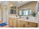 Bright bathroom with double vanity and framed mirrors, with a large window providing lots of light at 4012 Owlshead Mountain St, Las Vegas, NV 89129