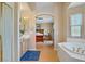 Bright primary bathroom with tub, shower, double vanity, and view into the primary bedroom at 4012 Owlshead Mountain St, Las Vegas, NV 89129
