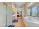 Bright primary bathroom with tub, shower, double vanity, and view into the primary bedroom at 4012 Owlshead Mountain St, Las Vegas, NV 89129