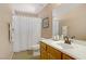 Neutral bathroom featuring a wooden vanity with an integrated sink, shower with a white curtain, and coordinating fixtures at 4012 Owlshead Mountain St, Las Vegas, NV 89129