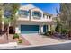 Charming two-story home with a paved driveway, beautiful landscaping, and a blue garage door at 4012 Owlshead Mountain St, Las Vegas, NV 89129