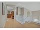 Bright, open hallway with wooden floors and white railings leading to rooms with neutral walls at 4012 Owlshead Mountain St, Las Vegas, NV 89129