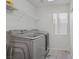 Clean laundry room with modern, front-loading washer and dryer, plus storage shelf, for laundry needs at 4012 Owlshead Mountain St, Las Vegas, NV 89129