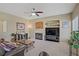 Comfortable living room with fireplace, ceiling fan, and neutral carpet at 4012 Owlshead Mountain St, Las Vegas, NV 89129