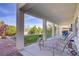 Covered patio with outdoor seating overlooks a well-manicured yard, perfect for relaxing and entertaining at 4012 Owlshead Mountain St, Las Vegas, NV 89129