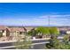 Neighborhood street view showcasing lush greenery, sidewalks and a glimpse of the city skyline in the background at 4012 Owlshead Mountain St, Las Vegas, NV 89129
