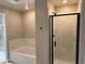 Bathroom featuring a tub with a faux marble backsplash and a separate glass-enclosed shower at 4388 Cave Lake Ave, North Las Vegas, NV 89032