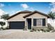 Charming single-story home with a two-car garage, neutral stucco, rock landscaping and a covered front porch at 4392 Cave Lake Ave, North Las Vegas, NV 89032