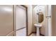 Stylish powder room with a pedestal sink, decorative mirror, and neutral color scheme at 524 Blanche Ct, Henderson, NV 89052