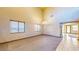 Spacious living room featuring neutral carpet, large windows, and modern chandelier fixture at 524 Blanche Ct, Henderson, NV 89052