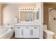 Modern bathroom with a soaking tub, sleek vanity with white cabinets, and a glass-enclosed shower at 601 Bear Grass St, Las Vegas, NV 89144