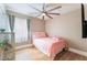 Cozy bedroom features wood floor, ceiling fan and a twin size bed with pink bedding and accents at 601 Bear Grass St, Las Vegas, NV 89144