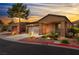 Charming single-story home featuring a well-maintained front yard and inviting covered porch at sunset at 601 Bear Grass St, Las Vegas, NV 89144