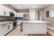 Modern kitchen boasts white cabinetry, stainless steel appliances, granite counters, and an island at 601 Bear Grass St, Las Vegas, NV 89144