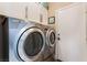 Functional laundry room featuring white cabinets, door and modern washer and dryer at 601 Bear Grass St, Las Vegas, NV 89144