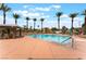 Community swimming pool with lounge chairs surrounded by lush palm trees on a sunny day at 601 Bear Grass St, Las Vegas, NV 89144