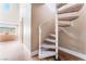 Carpeted spiral staircase featuring an adjacent light wood floor, a light-filled window, and neutral paint at 601 Bear Grass St, Las Vegas, NV 89144