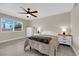 Cozy bedroom with a ceiling fan, wood-look floors, and a large window with a view at 608 W Mcdermit St, Las Vegas, NV 89107