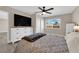 Bedroom with wood-look floors, ceiling fan, dresser, TV, and window with neighborhood views at 608 W Mcdermit St, Las Vegas, NV 89107