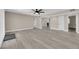 Spacious living room features modern gray laminate flooring and a ceiling fan at 608 W Mcdermit St, Las Vegas, NV 89107
