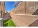 Private backyard featuring low-maintenance landscaping with brick pavers and synthetic lawn at 632 Twilight Blue Ave, North Las Vegas, NV 89032