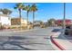 Entryway to the community with palm trees, landscaped entrance, and dark metal gate for privacy and security at 648 Sumatra Pl, Henderson, NV 89011