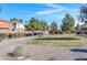 Community park featuring gravel areas, trees, green grass, benches, walking path, and playground equipment in the distance at 648 Sumatra Pl, Henderson, NV 89011