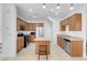 Well-lit kitchen features stainless appliances, granite countertops, wooden cabinets, and center island with attached breakfast bar at 648 Sumatra Pl, Henderson, NV 89011