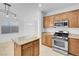 Bright kitchen features wood cabinets, stainless steel microwave and stovetop with window view of the backyard at 648 Sumatra Pl, Henderson, NV 89011