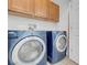 Laundry room with upper cabinets and blue washer and dryer at 648 Sumatra Pl, Henderson, NV 89011