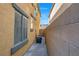 An image of a narrow side yard featuring essential HVAC equipment, concrete surface and adjacent wall for secure separation at 648 Sumatra Pl, Henderson, NV 89011