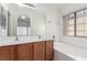 Bathroom featuring dual sinks, a bathtub and a window for natural light at 6489 Coldwater Bay Dr, Las Vegas, NV 89122