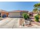 Single-story home with two-car garage, tile roof, xeriscaping, and desert landscaping in the front yard at 6489 Coldwater Bay Dr, Las Vegas, NV 89122