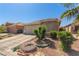Landscaped single-story home with two-car garage, tile roof, and desert landscaping at 6489 Coldwater Bay Dr, Las Vegas, NV 89122