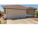 Close up of the garage door and front facade of this single-story home with tile roof at 6489 Coldwater Bay Dr, Las Vegas, NV 89122