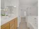 Bright bathroom with tub shower, vanity, and tile floors leading to adjoining rooms, offers convenience at 6625 Pine Siskin Pl, North Las Vegas, NV 89084